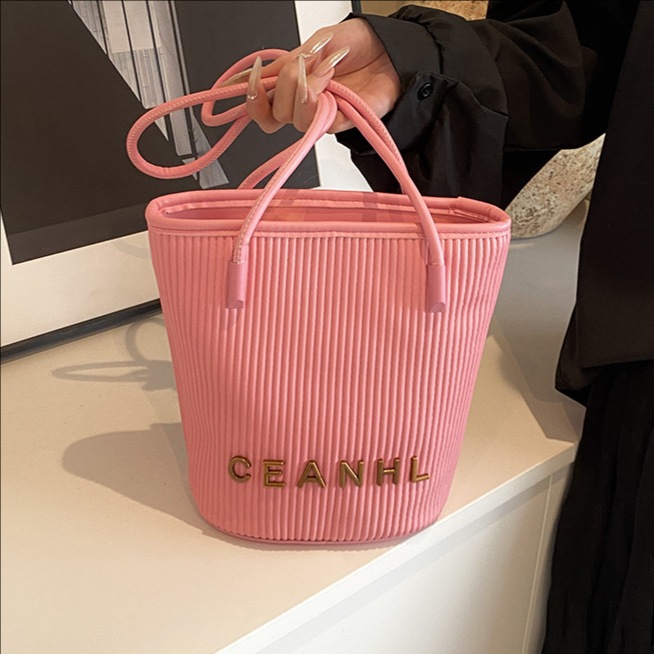 2025 otoño y invierno nuevo pequeño bolso a rayas de viento fragante bolso de cubo simple bolso de hombro de tendencia de mujeres bolso de mochila popular