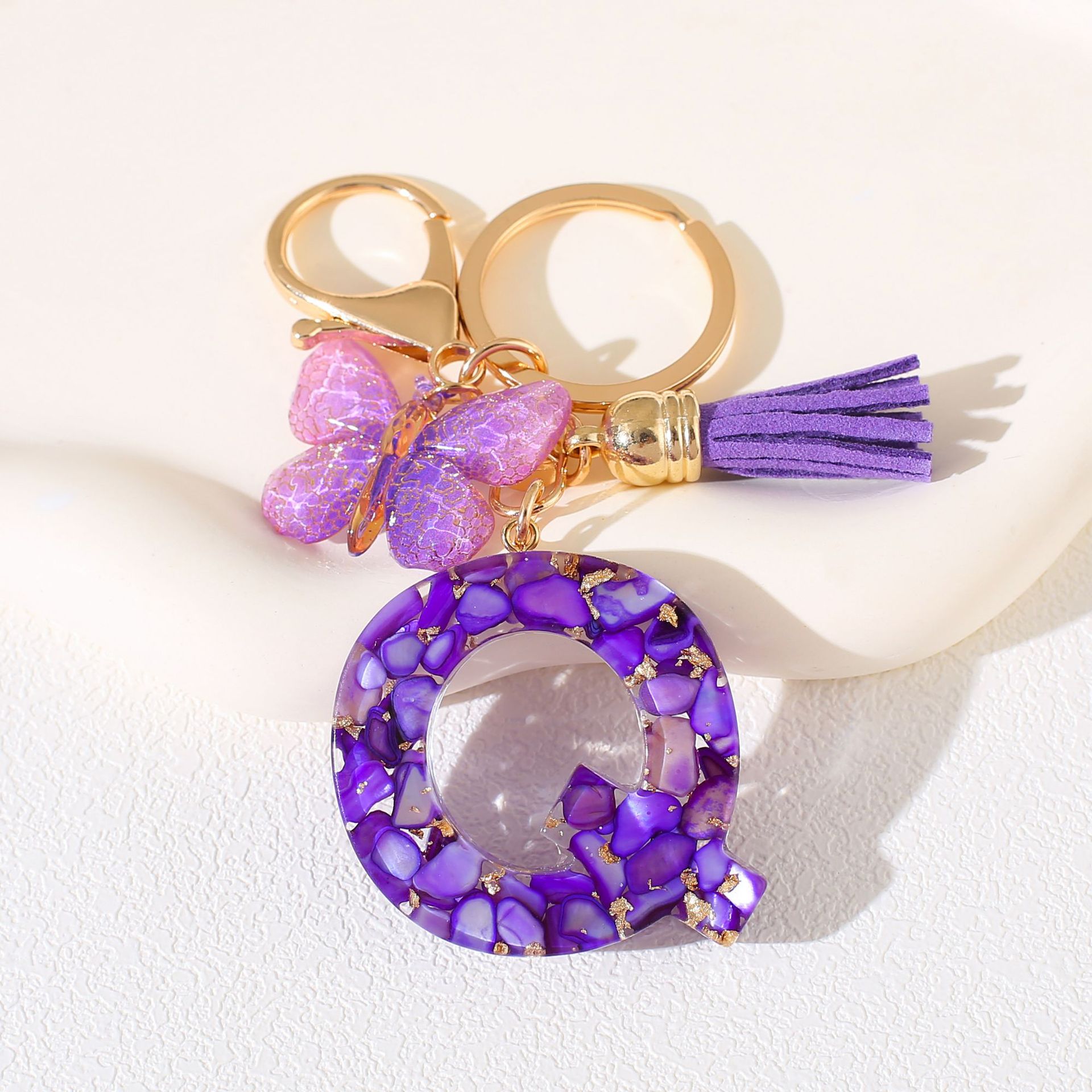 Fábrica directa de Yiwu accesorios de resina de goteo de embalaje llavero anillo de metal letras mariposa brilla colgante damas