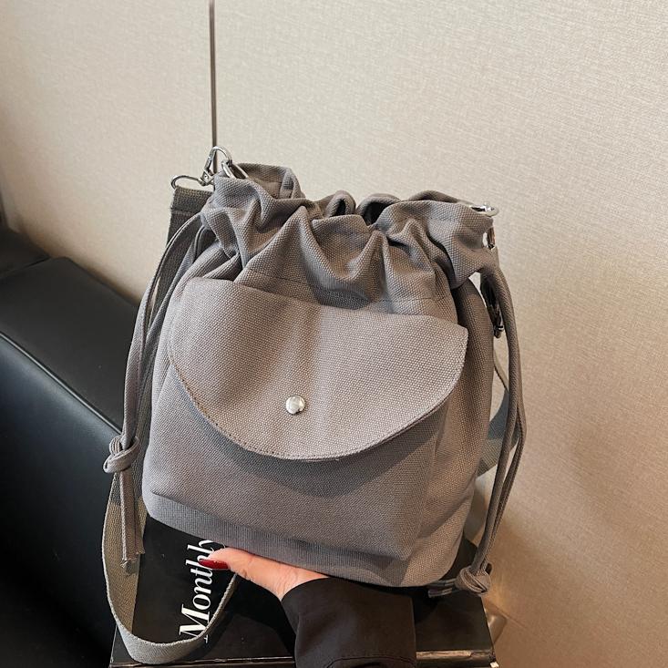 Bolsa de cubo de lona de moda de comercio exterior para mujeres 2025 nuevo estilo versátil bolso de hombro simple ocio nicho plegado mochila