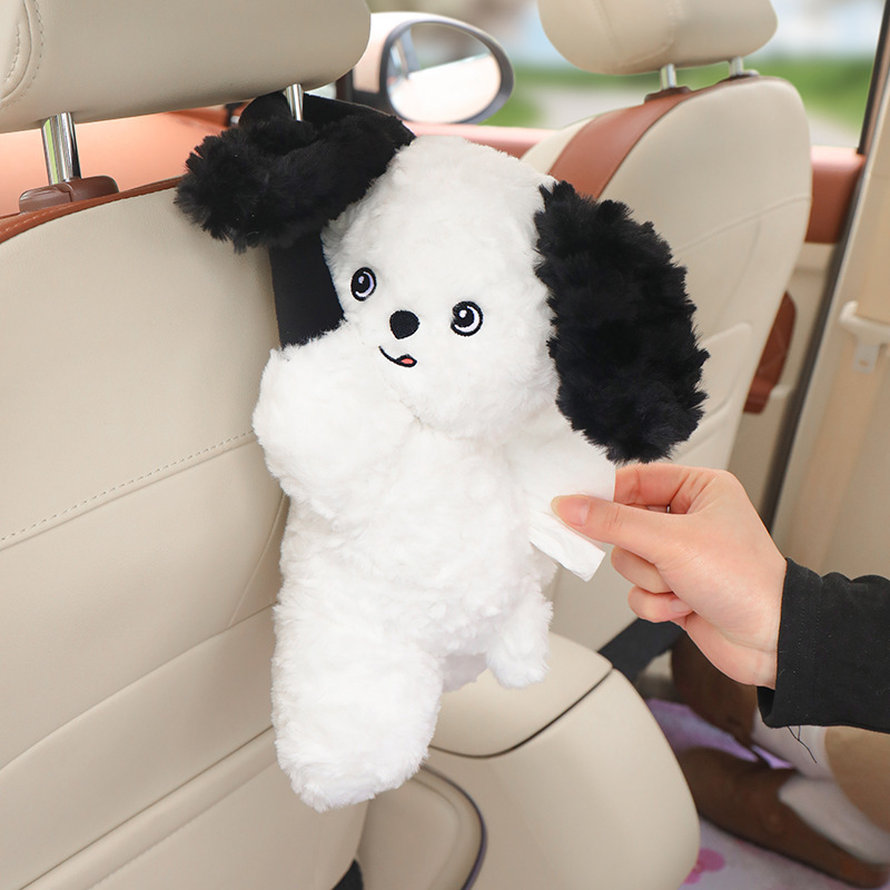 車のティッシュの箱のかわいい子犬のぬいぐるみがうつぶせになります。|undefined
