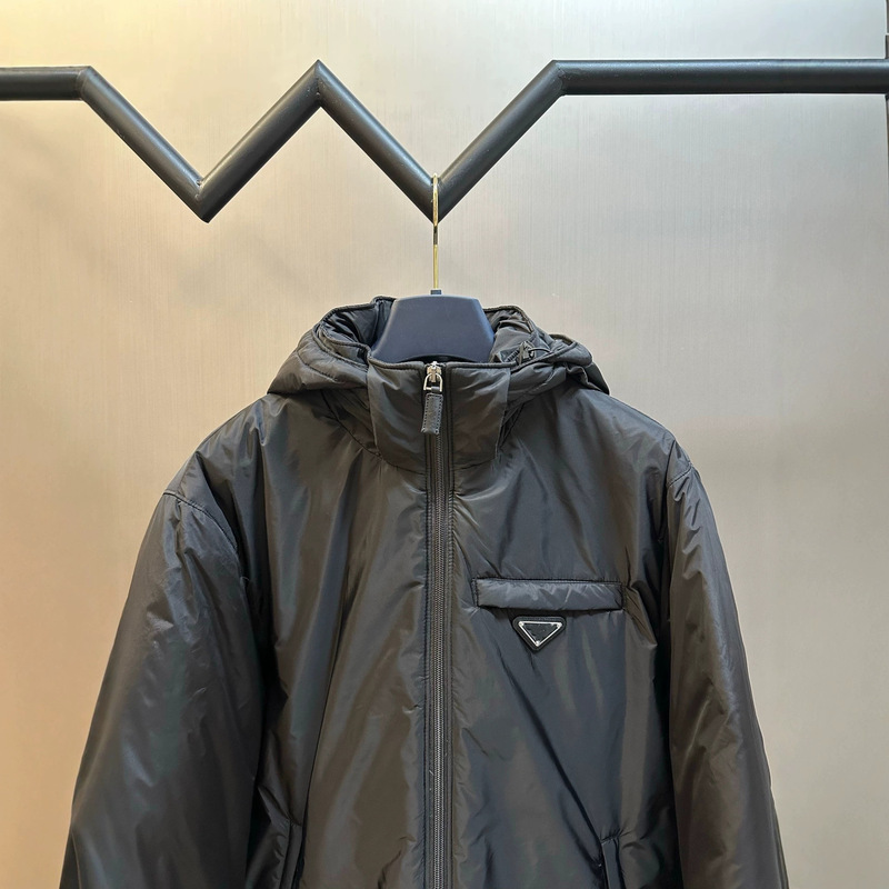 High-end export-quality P brand 26s autumn/winter collection, featuring a triangular logo, a hooded design, and a thickened down filling, available in unisex styles High-end export-quality P brand 26s autumn/winter collection, featuring a triangular logo, a hooded design, and a thickened down filling, available in unisex styles