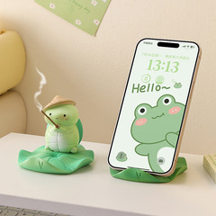 カエルのかわいい携帯電話のスタンドの事務室のデスクトップのプレゼントの漫画の怠惰な人は劇の平板を追いかけて支えます。