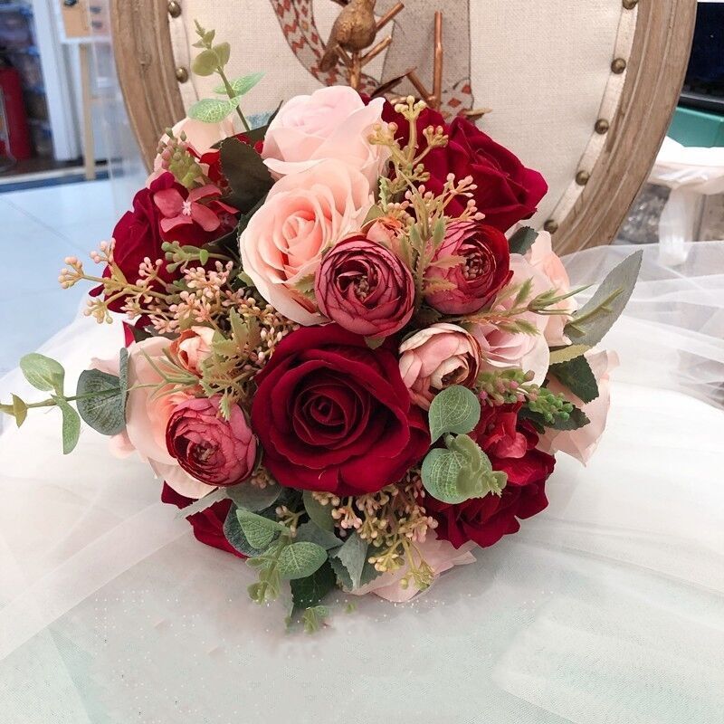 手に花を持つ新婦の韓国式結婚式の領収書のシミュレーションの花束の森系のウェディングドレスの撮影の道具の手に花をささげます。|undefined