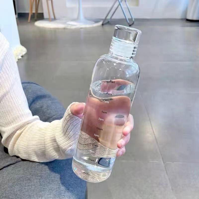 時間の漂流瓶の目盛りのグラスは外出して高い顔の値の透明な蓋のジュースの杯のネットの赤い温度のコップを持ちます。|undefined