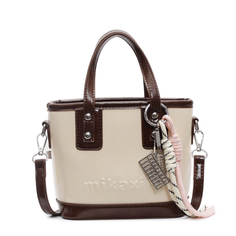 Retro brillante bolso de cubo de mano 2025 nuevo estilo bolso de hombro de color contrastante sensación de alto nivel bolso de mochila casual simple