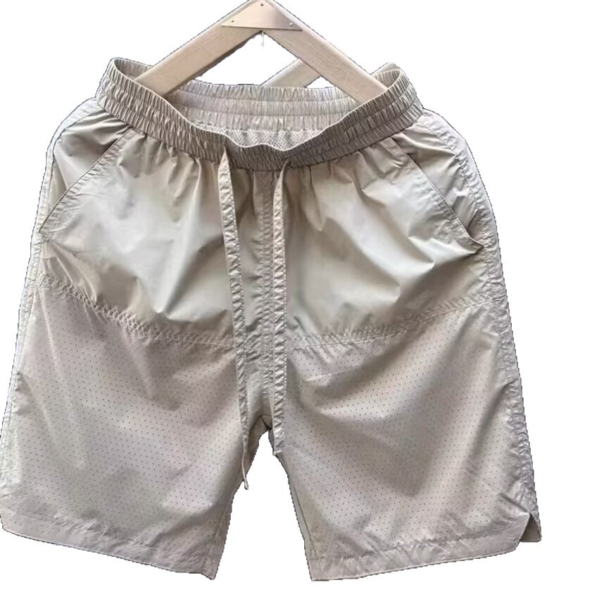 Verano nuevo estilo láser perforado transpirable pantalones cortos casuales hombres simples y de moda todo fósforo sueltos de seda de hielo de secado rápido pantalones de cinco puntos