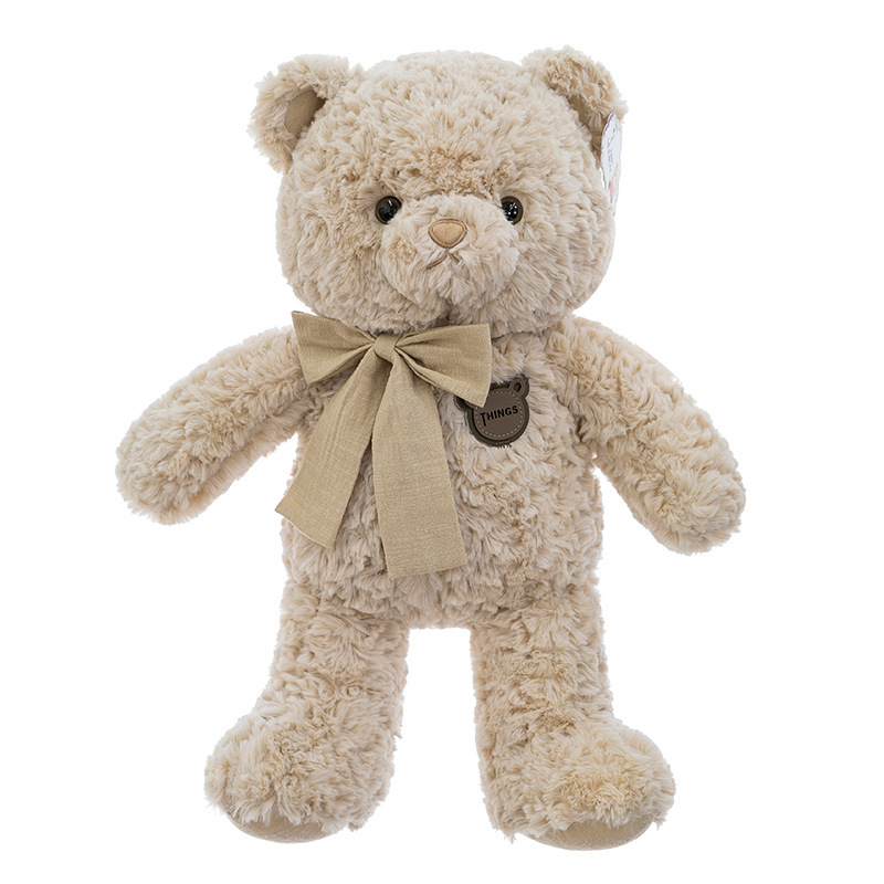 ブラシの花の蝶結びのテディベアのぬいぐるみの子供は寝ます。|undefined