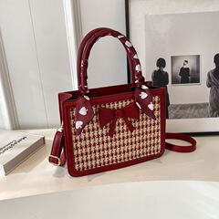 千鳥格の花嫁は質感の結婚バッグを包んでいます。