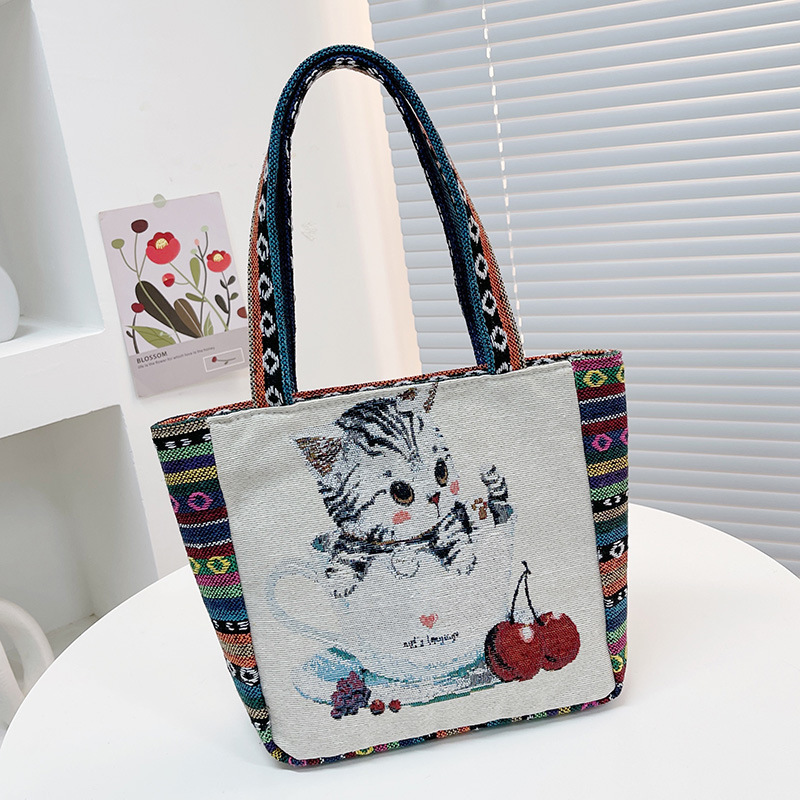 国境を越えた刺繍キャンバスのハンドバッグは女性民族風のハンドバッグを持ってカジュアルなマミーバッグのサラリーマンが弁当袋を持っている|undefined