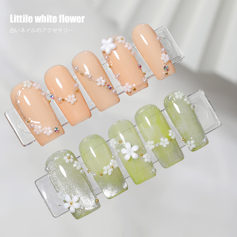 Popular manicura popular en línea pequeña flor blanca tamaño blanco mezclado flor de cinco pétalos con pequeña bola de acero tridimensional decoración de uñas de resina