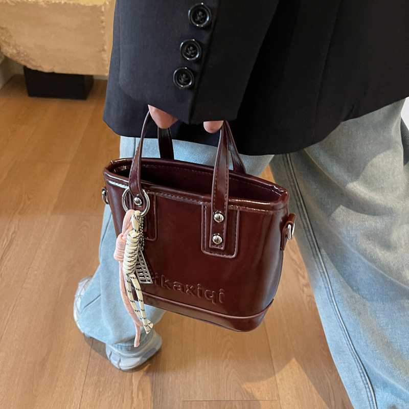 Retro brillante bolso de cubo de mano 2025 nuevo estilo bolso de hombro de color contrastante sensación de alto nivel bolso de mochila casual simple