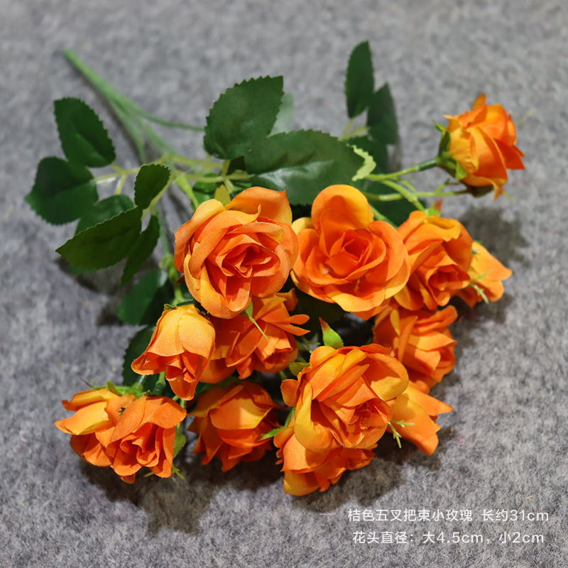 Una rosa pequeña con un manojo naranja de cinco puntas