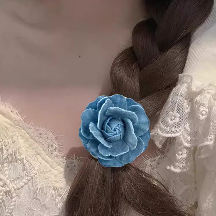 Vintage denim stoffen camelia broche, een elegant driedimensionaal accessoire voor dames._voghion.com