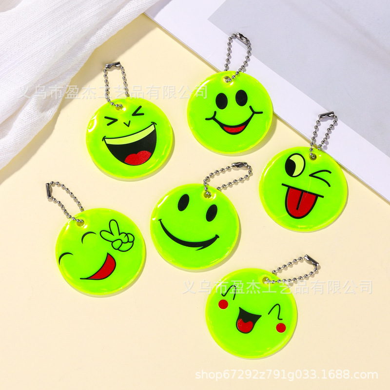 Muchos colgantes reflectantes transfronterizos sonrientes para niños viajan por la noche PVC seguro al aire libre