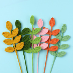 完成品の手作りのかぎ針編みの花束は毛糸編みの7葉の四季の葉を編みます。