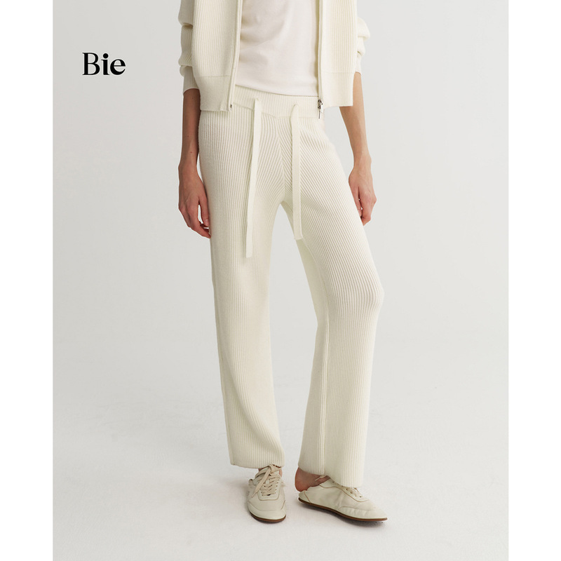 Minimalist and comfortable knit pants for women, featuring a drawstring, loose fit, long length, relaxed drape, slimming effect, and straight-leg design for a casual look Minimalist and comfortable knit pants for women, featuring a drawstring, loose fit, long length, relaxed drape, slimming effect, and straight-leg design for a casual look