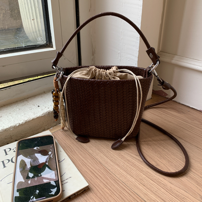 Transfronterizos bolsos de cubo de cuerda bolsos de mujer versátiles bolsos de mano otoño e invierno 2025 nuevo tejido mochila de viaje