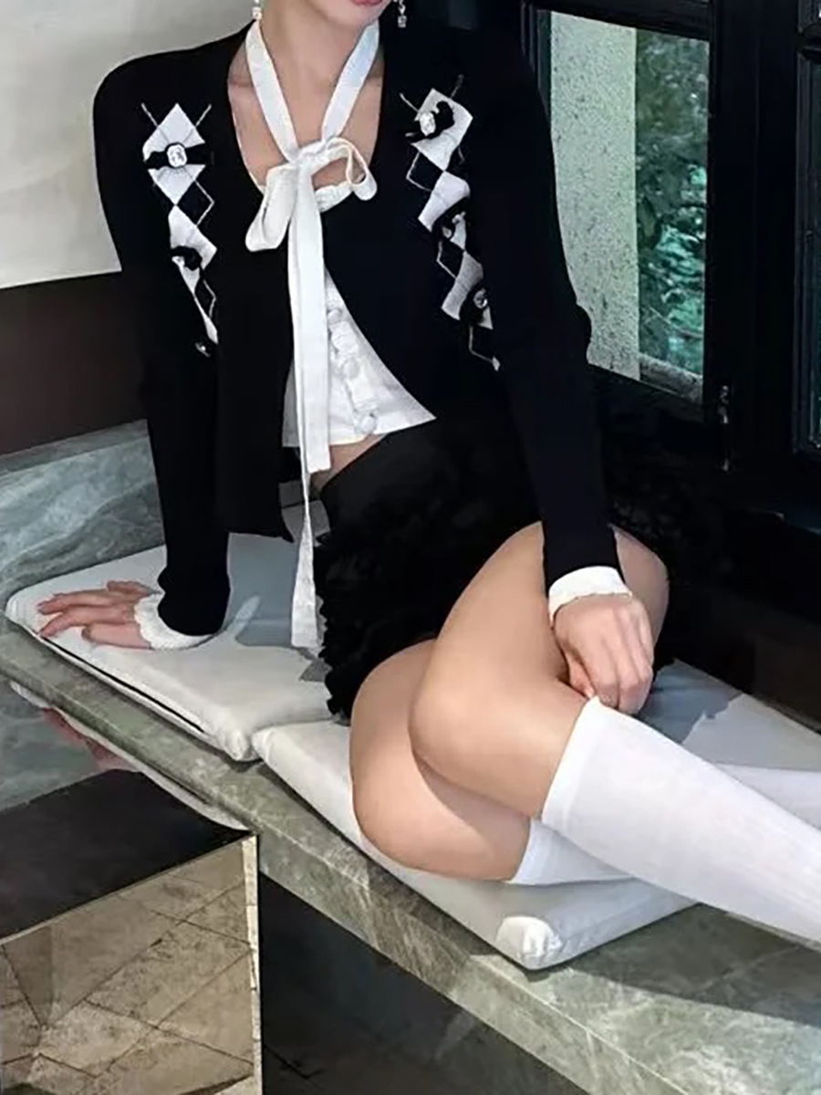 2025年の春の新商品のモダンな白黒の衝突色のリボンは菱格のニットの上着の秋のファッションの高級感をつなぎ合わせます。