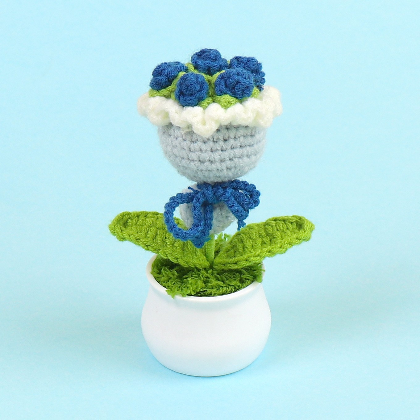 Maceta de flores en la mano azul