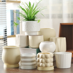A set of wholesale ceramic planters with trays, featuring a cream-style, light luxury, and high-end aesthetic, suitable for home use, includes orchids and succulents.