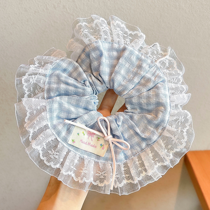 3#Coletero para el pelo a cuadros azules de unos 20 cm.