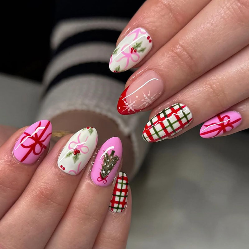 Medium almond-shaped red French manicure with Christmas tree, snowflake, and plaid patterns, decorated with gift bows and ribbons for Christmas