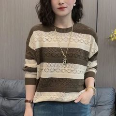 ゆったりとしたファッションの中年のお母さんは長袖の気質のメリヤスを抜きます。