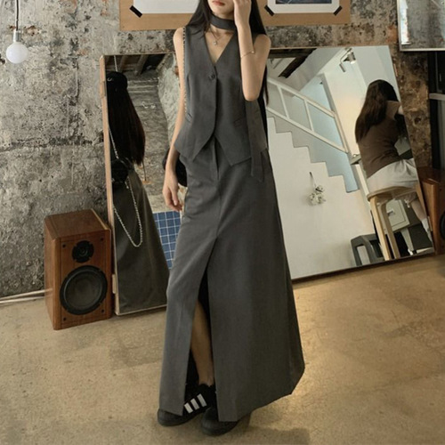 A vintage-style suit set with a sleeveless gray waistcoat for women, featuring a half-body skirt with slits for summer, exuding a sense of elegance - a two-piece set.