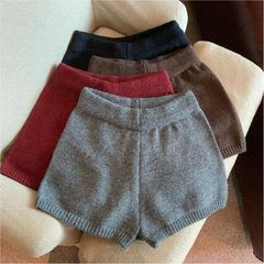 純色のニットの毛糸の半ズボンの女性の外は底を打ってヨガのズボンの高い腰を掛けて痩せています。