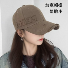 つばを広くして復古的に穴を割って、野球帽の女性が顔を見せます。