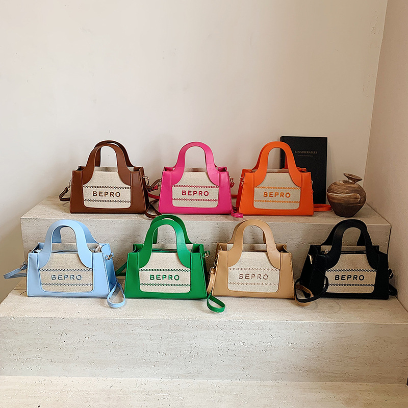 2026 estilo de moda letras impresión de mano mano de hombro oblíquo empalme de color nuevo bolso cuadrado simple europeo y americano