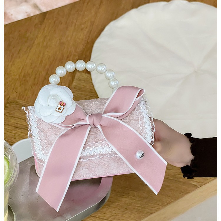 Otoño y invierno coreano arco camellia bolsas de niños de encaje de mano perlas bolsas mochilas para niñas de jardín de infantes