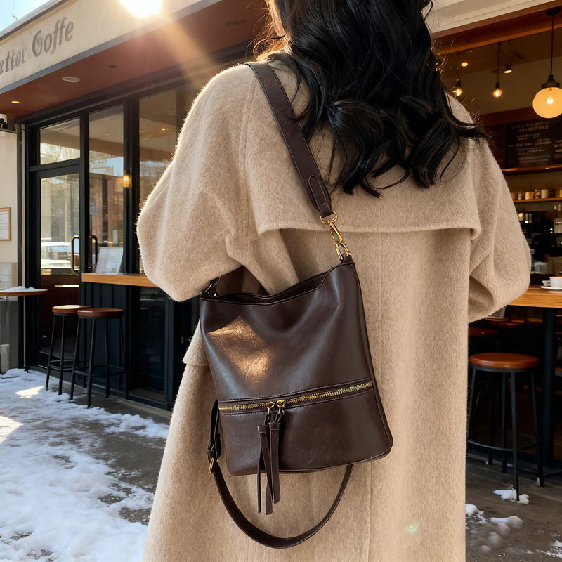 Nicho transfronterizo bolsos retro mujeres otoño y invierno 2025 nuevo estilo universal de viaje de un solo hombro bolso de cubo de alta sensación mochila