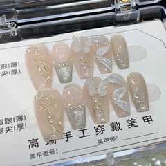 ネイルアートの完成品の爪を身につけて、氷透裸色のツバキの花の蝶の偽の爪の貼る光を治療します。