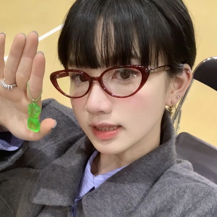 日本のレトロな赤い猫の目のメガネの学生の周囲の顔はやせています。|undefined