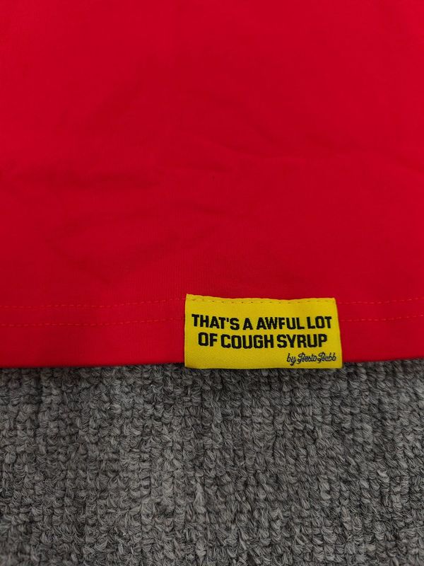 それはとても多くの咳止めシロップを意味する「AWFUL LOT OF COUGH SYRUP」のシャツです。虹色の文字が入ったクロスボーダーのトレンドブランドの半袖メンズシャツです。|undefined