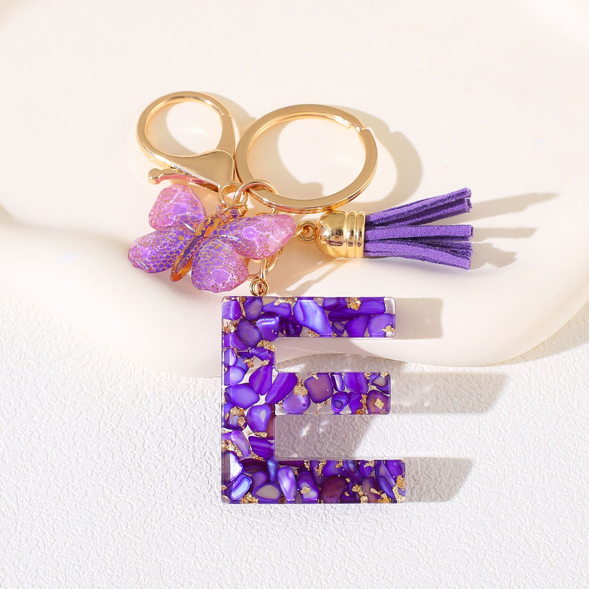 Fábrica directa de Yiwu accesorios de resina de goteo de embalaje llavero anillo de metal letras mariposa brilla colgante damas