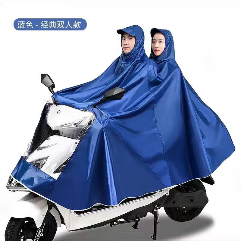 レインコート電気自動車のレインコートを大きくして、オートバイの二人のシングル男性女性が豪雨防止全身に足を隠します。|undefined