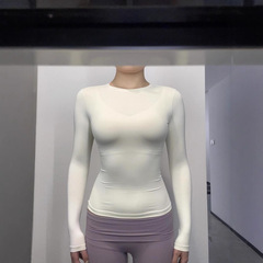Skimsギャルは腰の長袖tシャツを肩に収めて運動します。