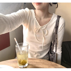 現物のライニングクリームの白い蝶結びの修身は底の柔らかいモチの中で貝殻の辺の長袖のtシャツの百合の上着を掛けます。