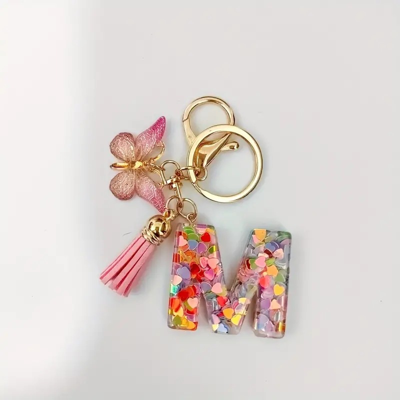 2024 transfronteriza en stock resina rosa con lentejuelas 26 letras inglesas llavero colgante mariposa borla Accesorios