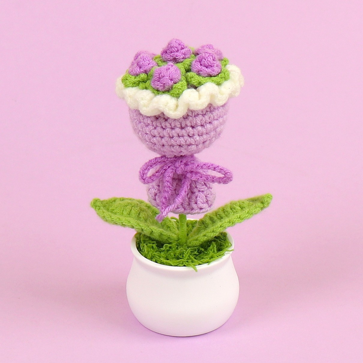 Maceta de flores en la mano morada