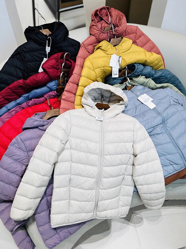 Chaqueta de plumón ligera para mujeres otoño y invierno 2025 nueva chaqueta de plumón de costillas con capuchón corto conveniente para almacenar chaqueta pequeña