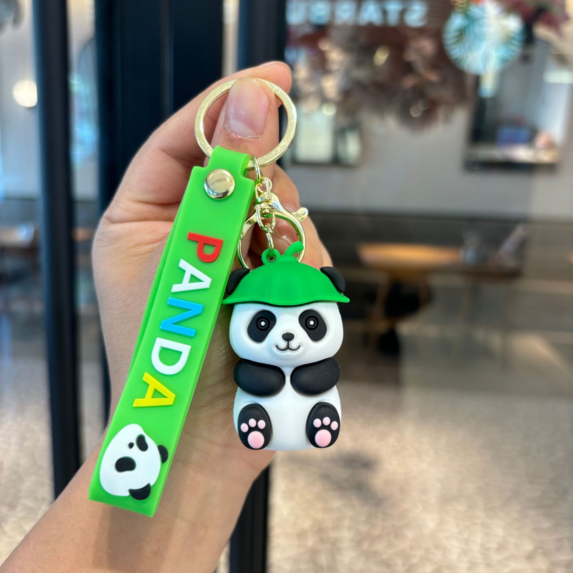 アニメは竹のパンダのキーホルダーを抱いてかわいいパンダのカップルの小銭入れを掛けます。
