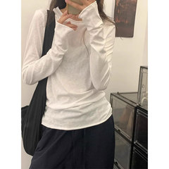 韓国系の巻き縁の白い肩の長袖のtシャツの女性の春秋の中で底のシャツを掛けて身を修めるのはやせている基礎の百合の上着です。