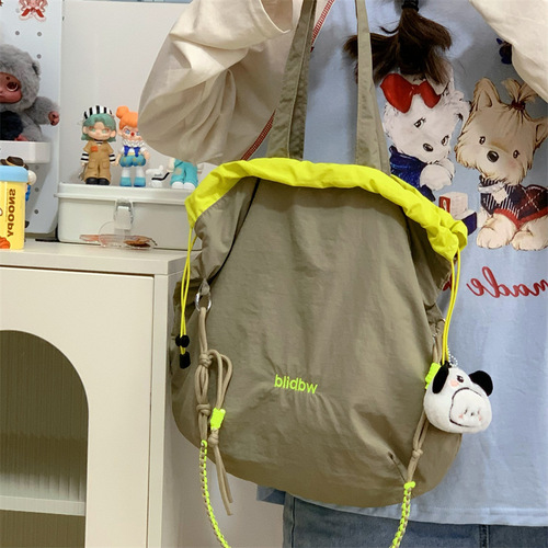 Korean style niche canvas bag, color-blocked drawstring, adjustable shoulder strap, multi-functional hand carry, contrasting color, lightweight cross-body shoulder bag