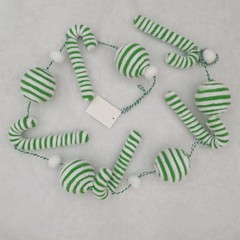 新しいクリスマス装飾品の祝日の雰囲気シーンにベルベットの縞模様の杖キャンディーがクリスマス帽を飾っている