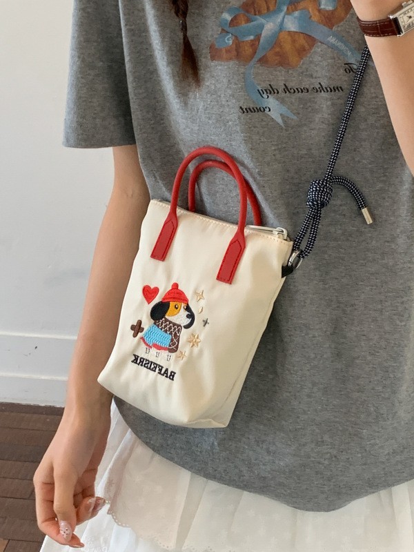 2026 nuevo estilo de alto nivel de sentido perezoso viento bordado portátil tipo cubo bolso de teléfono móvil lindo tela de nylon de color sólido mochila