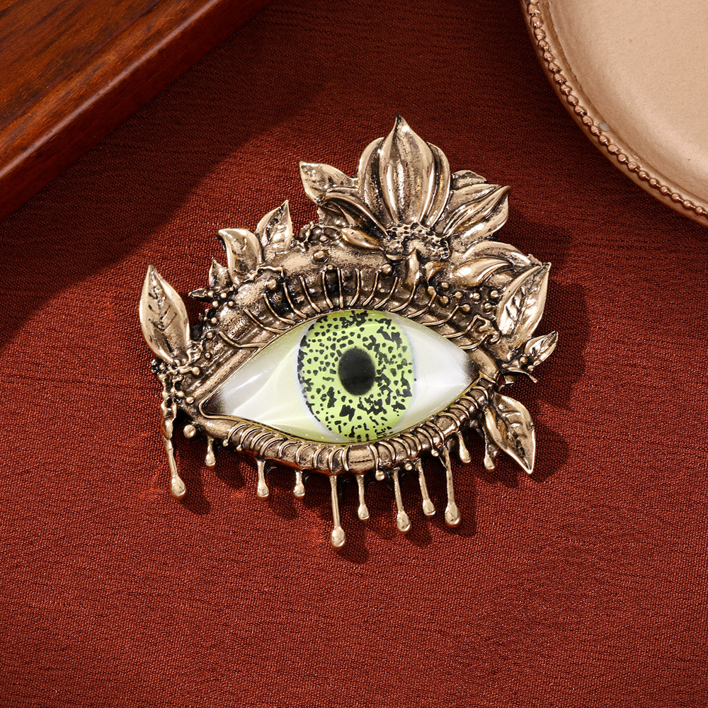 Broche vintage luxueuse et élégante haut de gamme, ornée de longs cils et d'un regard démoniaque, mettant en valeur une personnalité unique et exacerbée._voghion.com