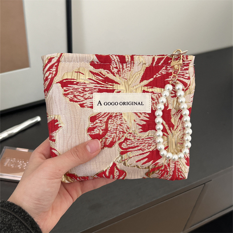 トランペットの高級感のある手は化粧バッグを持っています。布芸の財布を持っています。